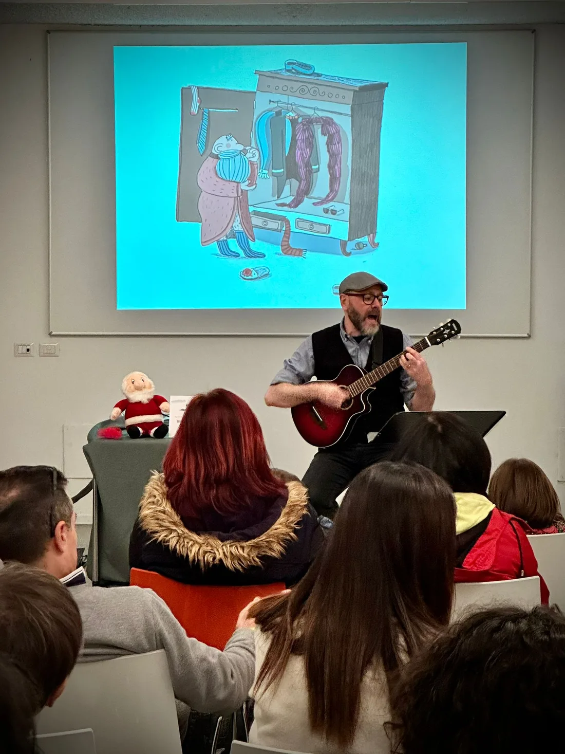Fabrizio Palma suona la chitarra davanti alla proiezione di Babbo Natale